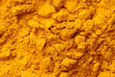 Photo of Aromatic turmeric powder as background, top view