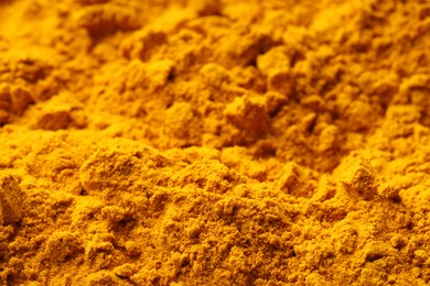 Photo of Aromatic turmeric powder as background, closeup view