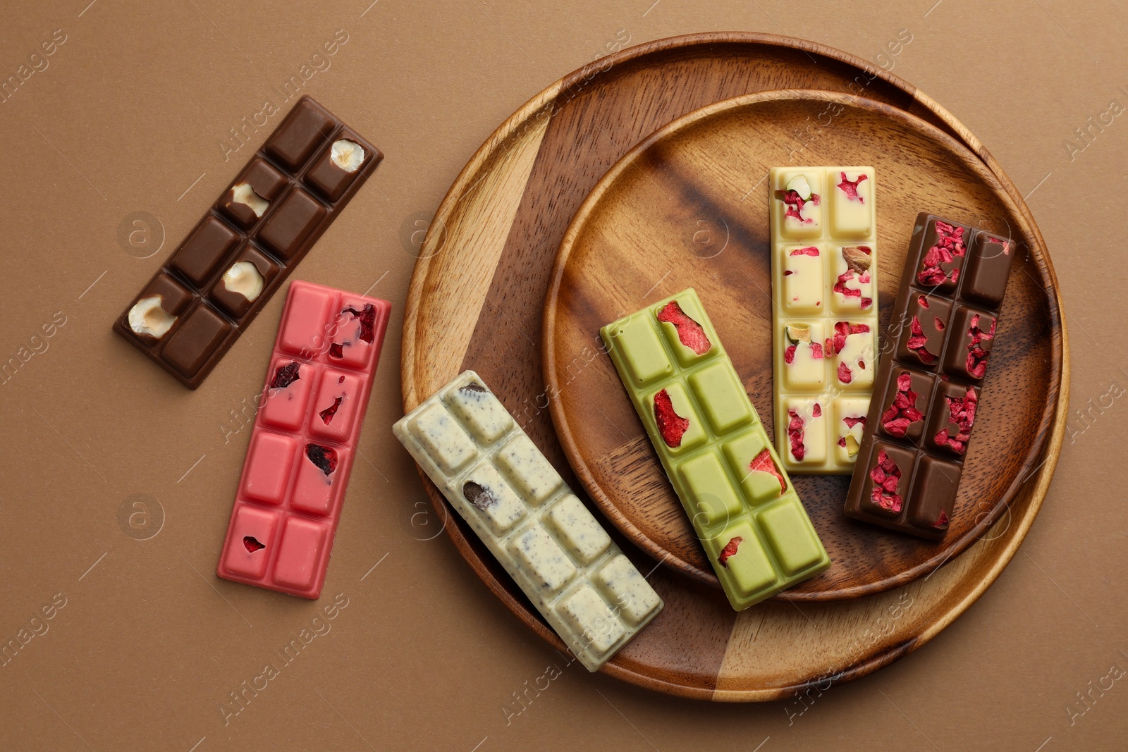 Photo of Different tasty chocolate bars on beige background, flat lay