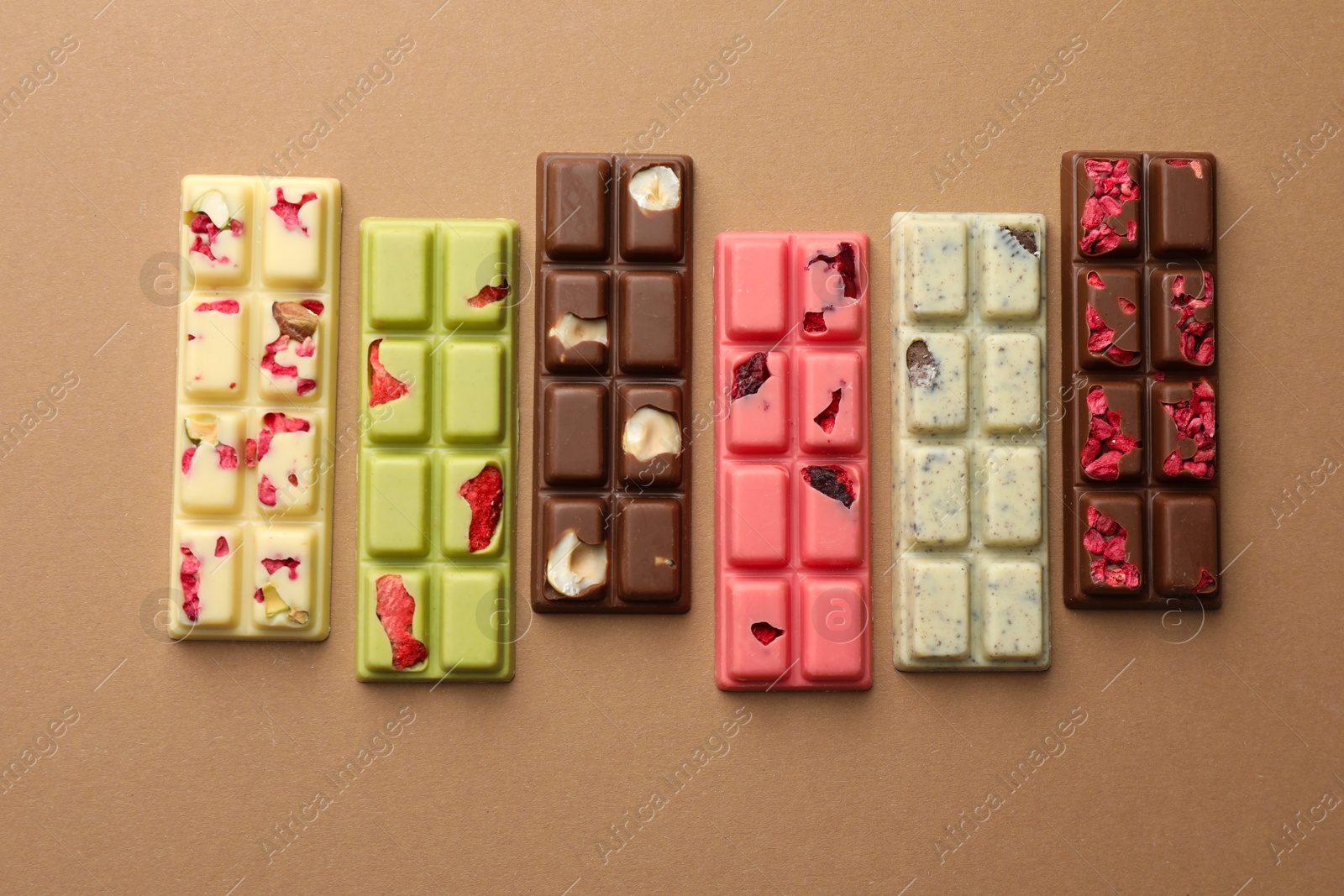 Photo of Different tasty chocolate bars on beige background, flat lay