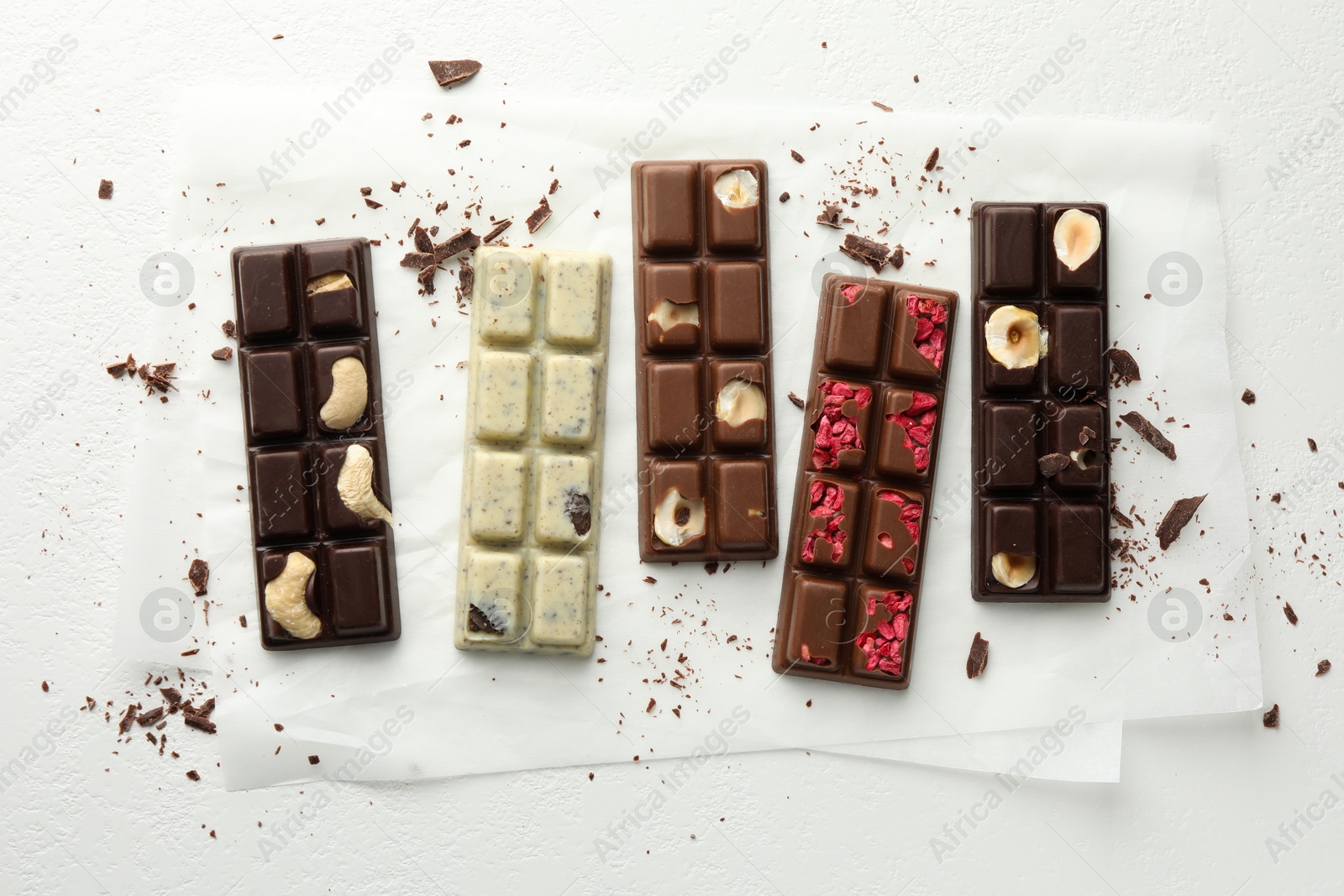 Photo of Tasty chocolate bars and crumbs on white background, flat lay