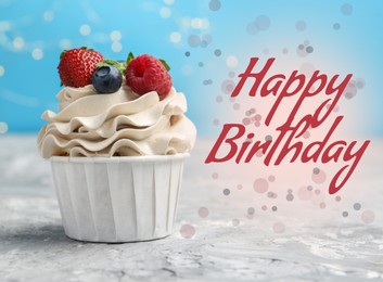 Happy Birthday greeting card. Sweet cupcake with berries on table