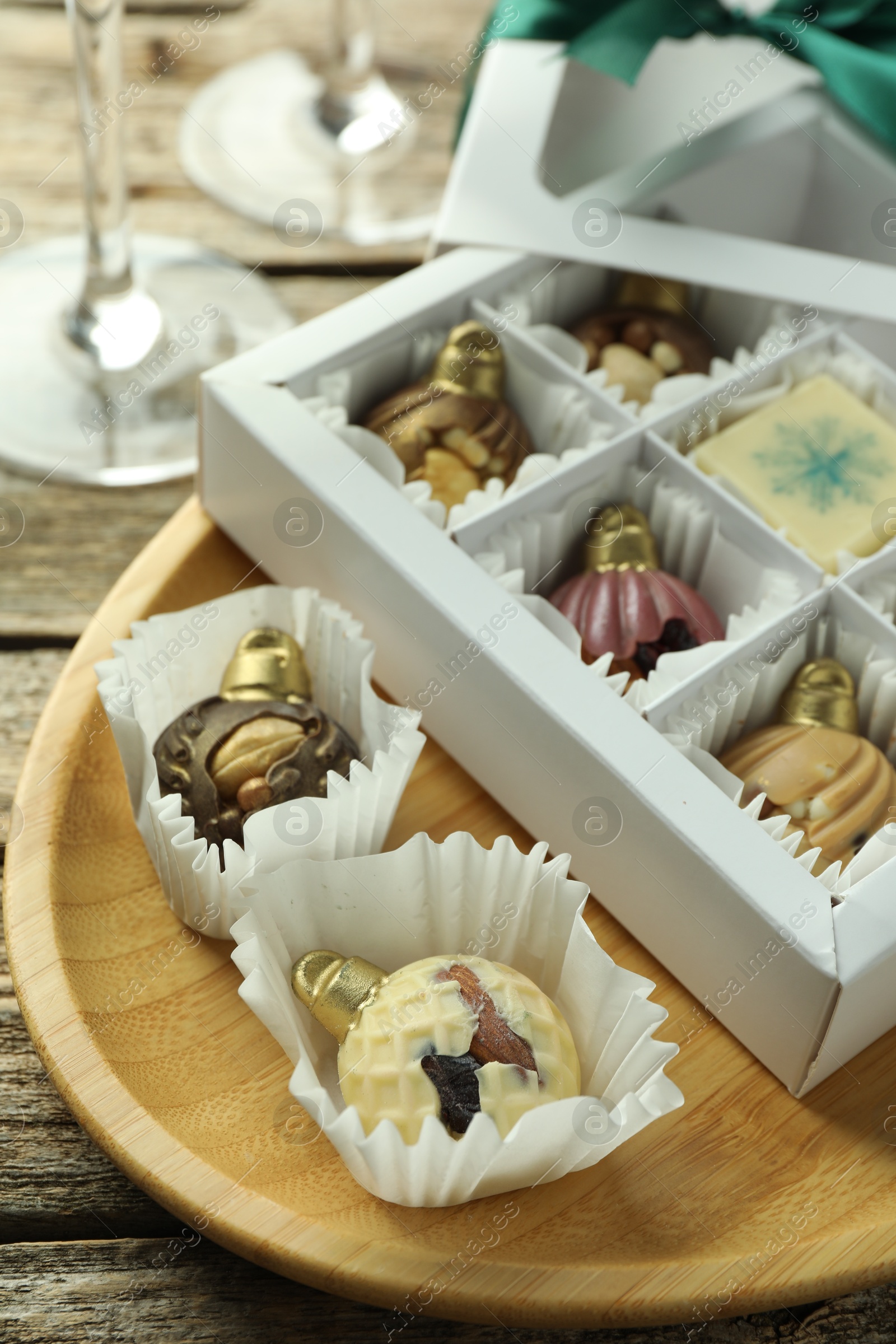 Photo of Box with tasty sweets in shape of baubles on wooden background, closeup