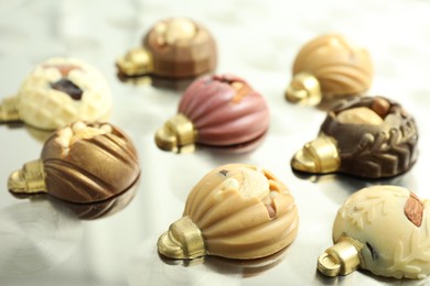 Photo of Different sweets in shape of baubles on light table, closeup