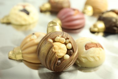 Photo of Different sweets in shape of baubles on light table, closeup