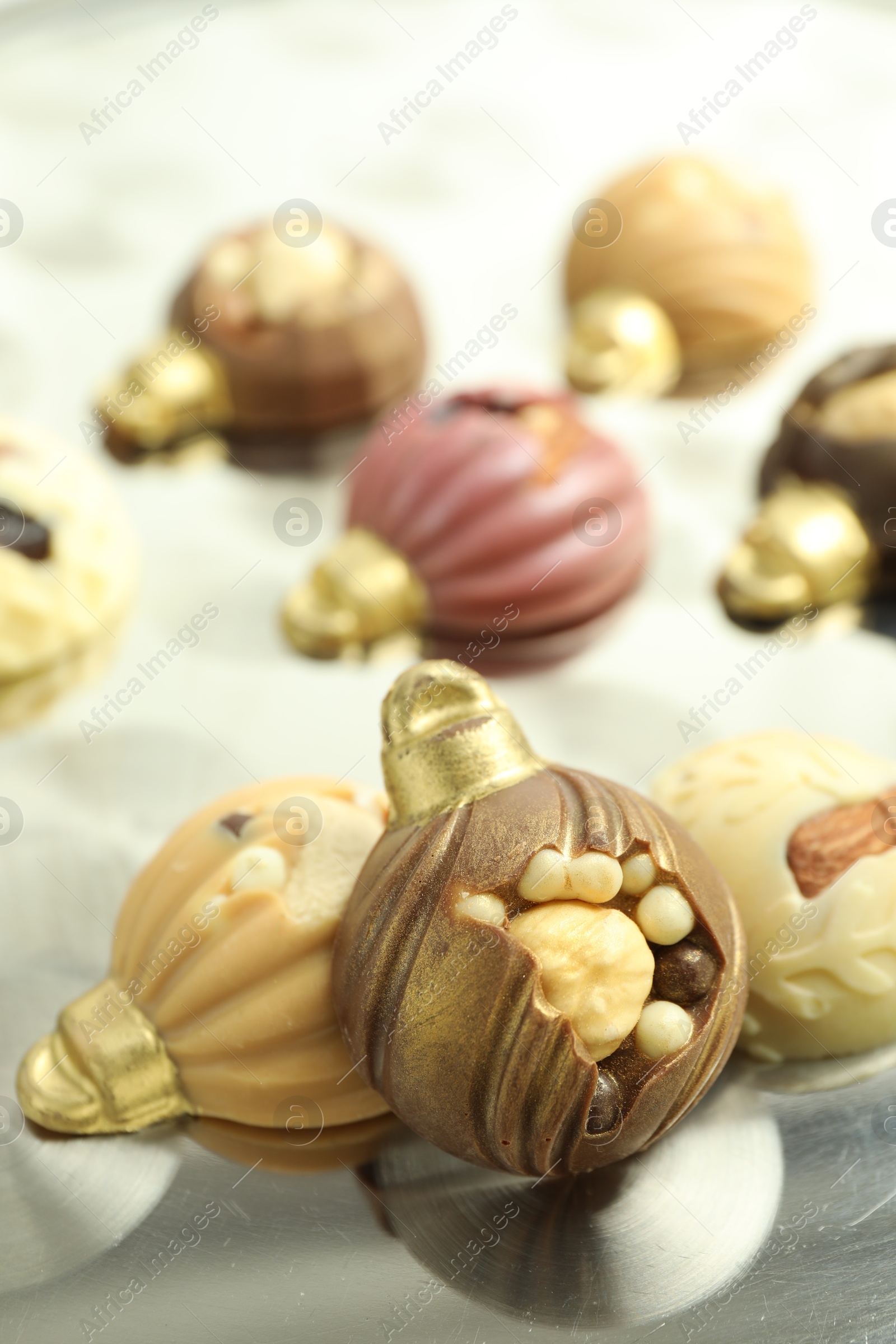 Photo of Different sweets in shape of baubles on light table, closeup