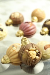 Photo of Different sweets in shape of baubles on light table, closeup