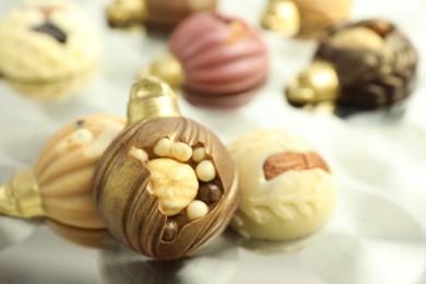 Photo of Different sweets in shape of baubles on light table, closeup