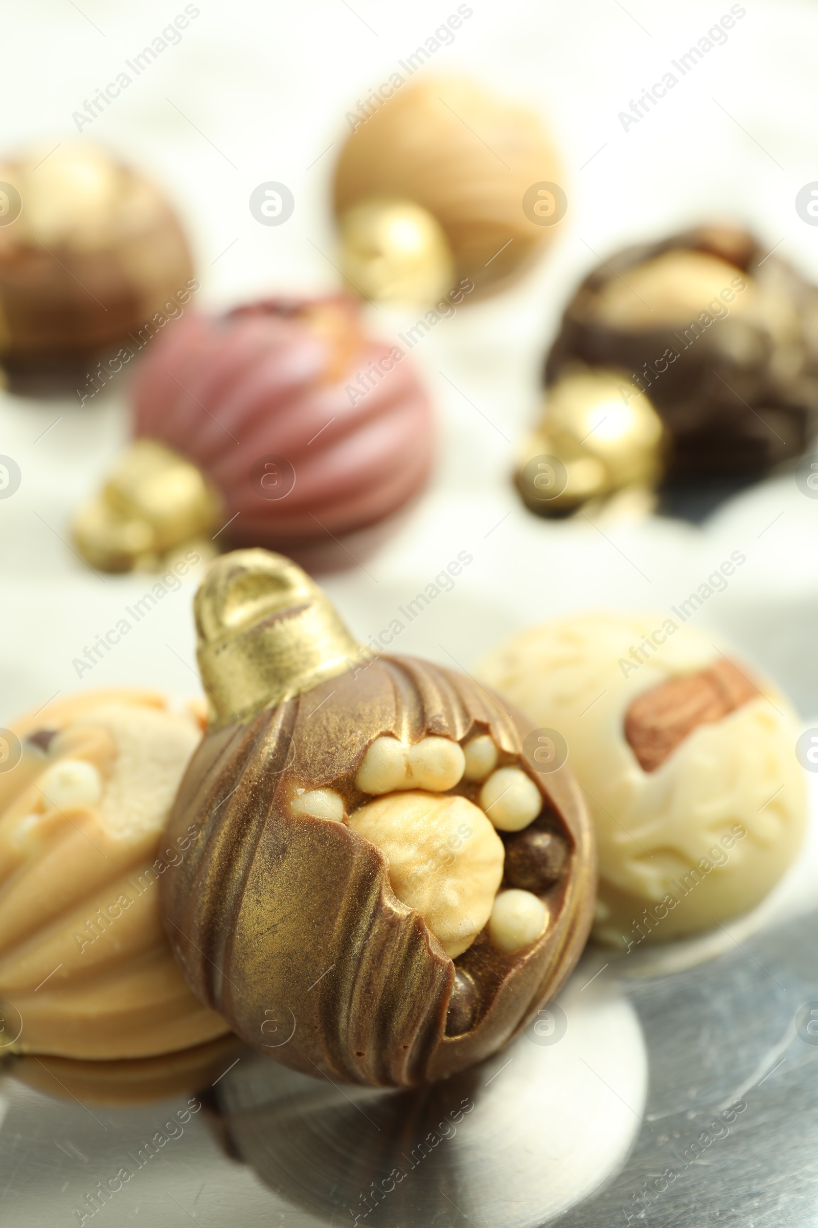 Photo of Different sweets in shape of baubles on light table, closeup