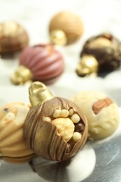 Photo of Different sweets in shape of baubles on light table, closeup