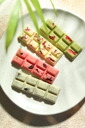 Photo of Delicious chocolate bars with different flavors on light table, top view