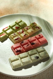 Photo of Delicious chocolate bars with different flavors on light textured table, closeup