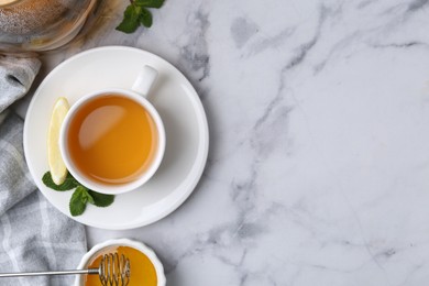 Photo of Aromatic mint, fresh leaves, lemon and honey on light marble table, flat lay. Space for text