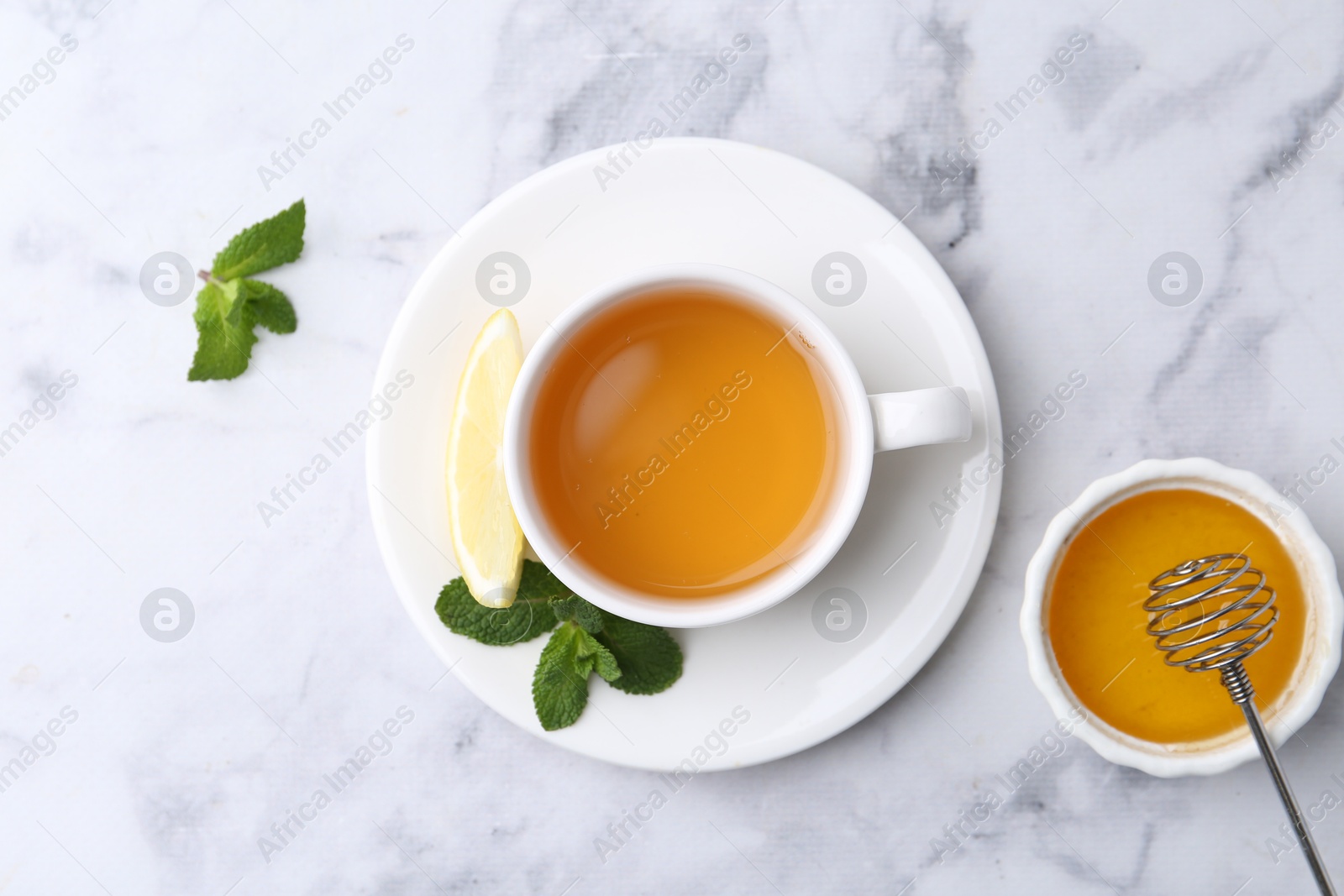 Photo of Aromatic mint, fresh leaves, lemon and honey on light marble table, flat lay