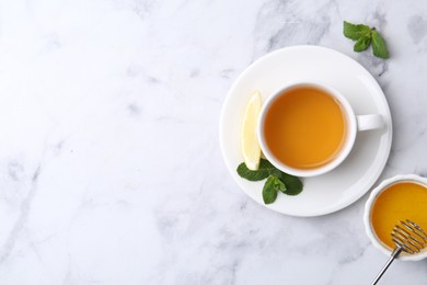 Photo of Aromatic mint, fresh leaves, lemon and honey on light marble table, flat lay. Space for text