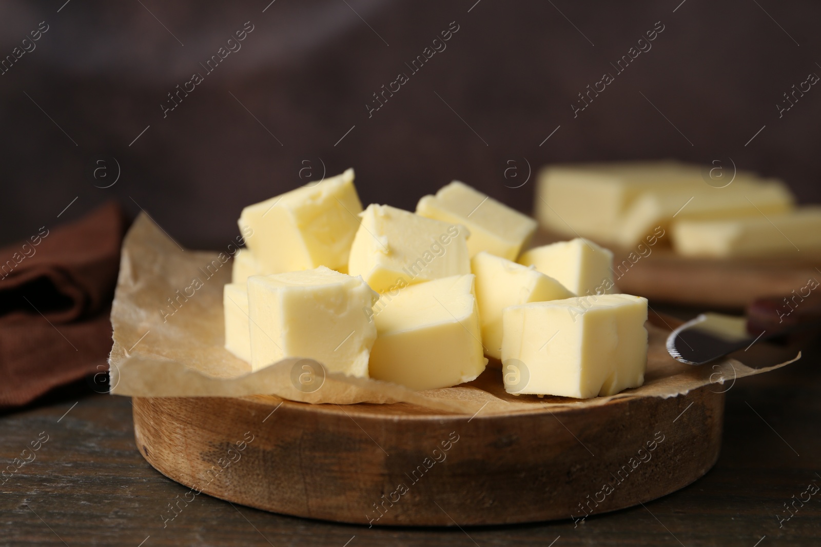 Photo of Pieces of fresh butter on wooden table, closeup