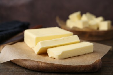 Photo of Pieces of fresh butter on wooden table, closeup