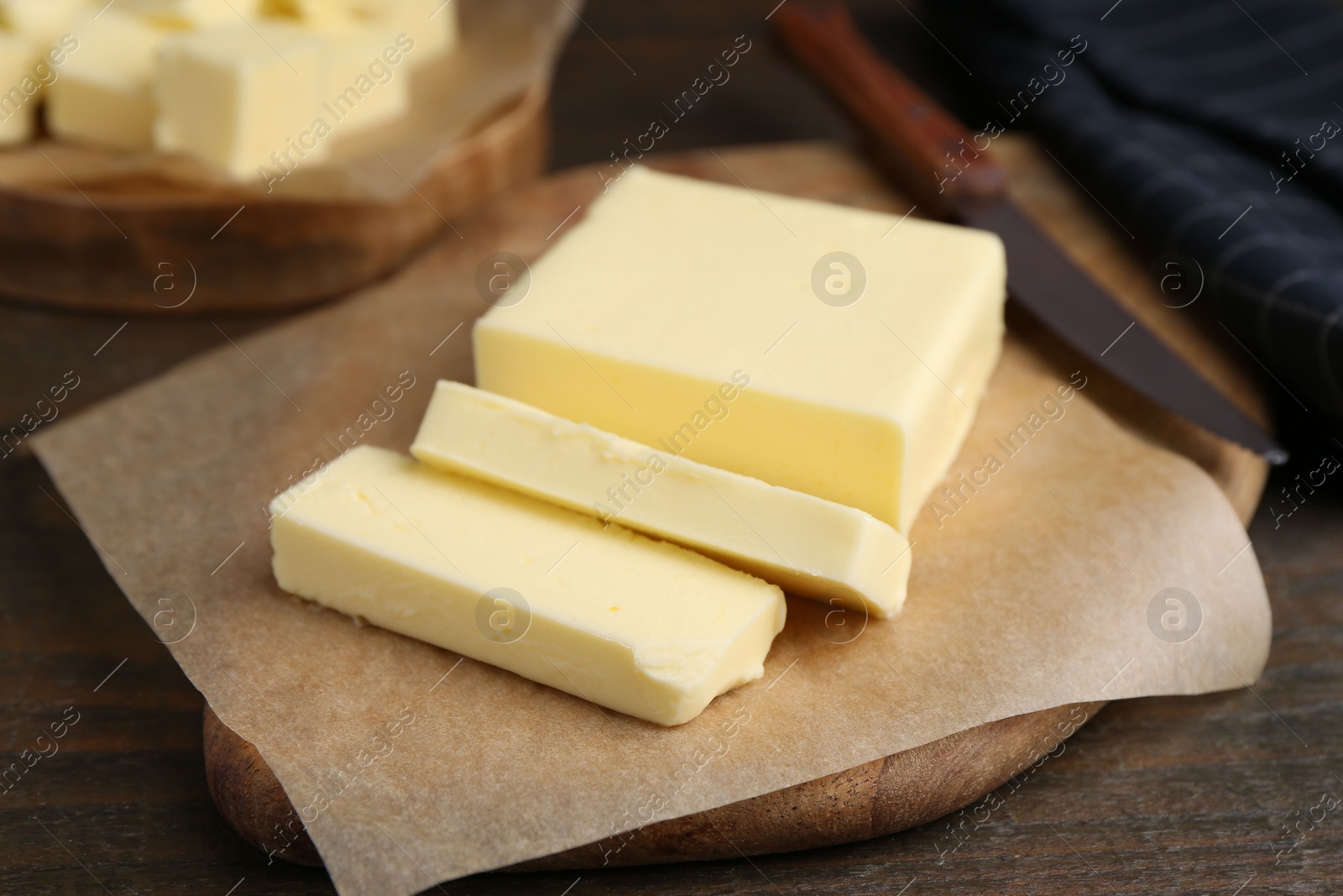 Photo of Pieces of fresh butter on wooden table, closeup