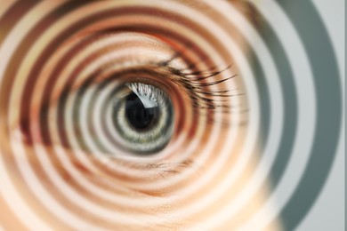 Image of Hypnosis. Spiral symbolizing hypnotic effect coming out of woman's eye, closeup