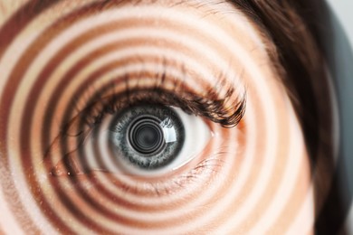 Image of Hypnosis. Spiral symbolizing hypnotic effect coming out of woman's eye, closeup