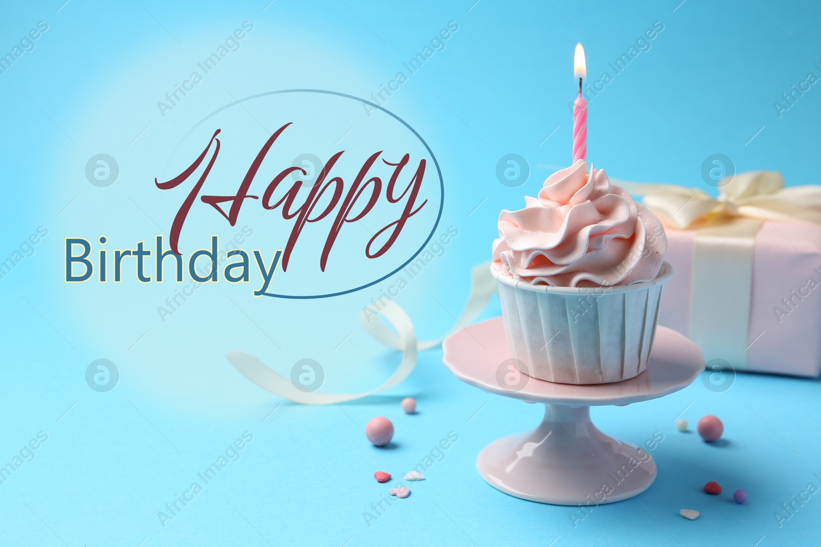 Image of Happy Birthday greeting card. Sweet cupcake with burning candle and gift box on light blue background