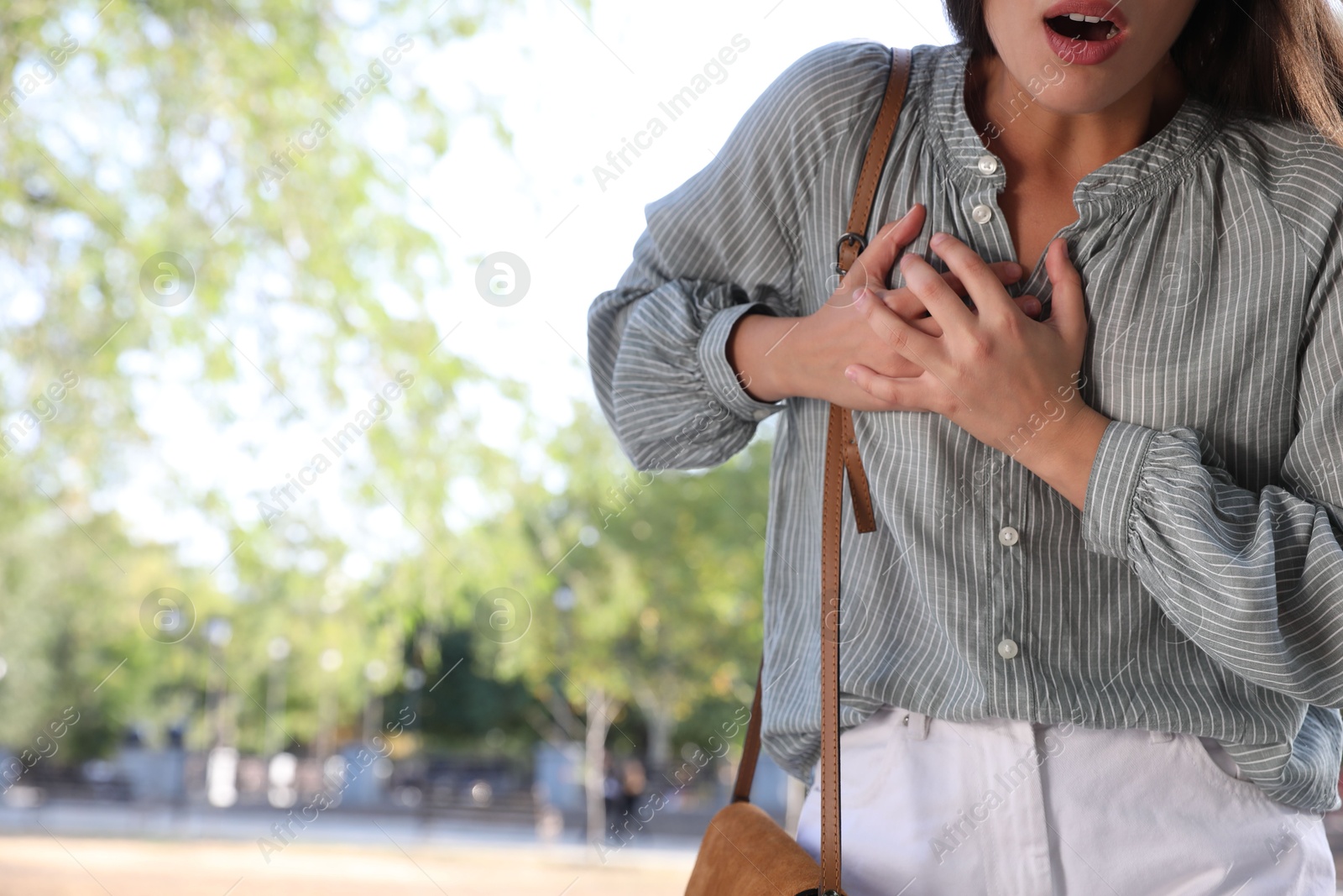 Photo of Young woman having heart attack in park, closeup