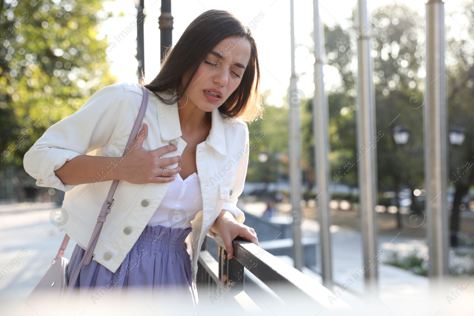 Photo of Young woman having heart attack on city street