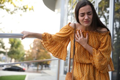 Young woman having heart attack on city street