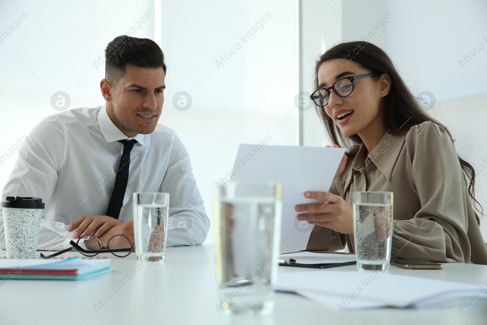 Photo of Office employees talking at table during meeting