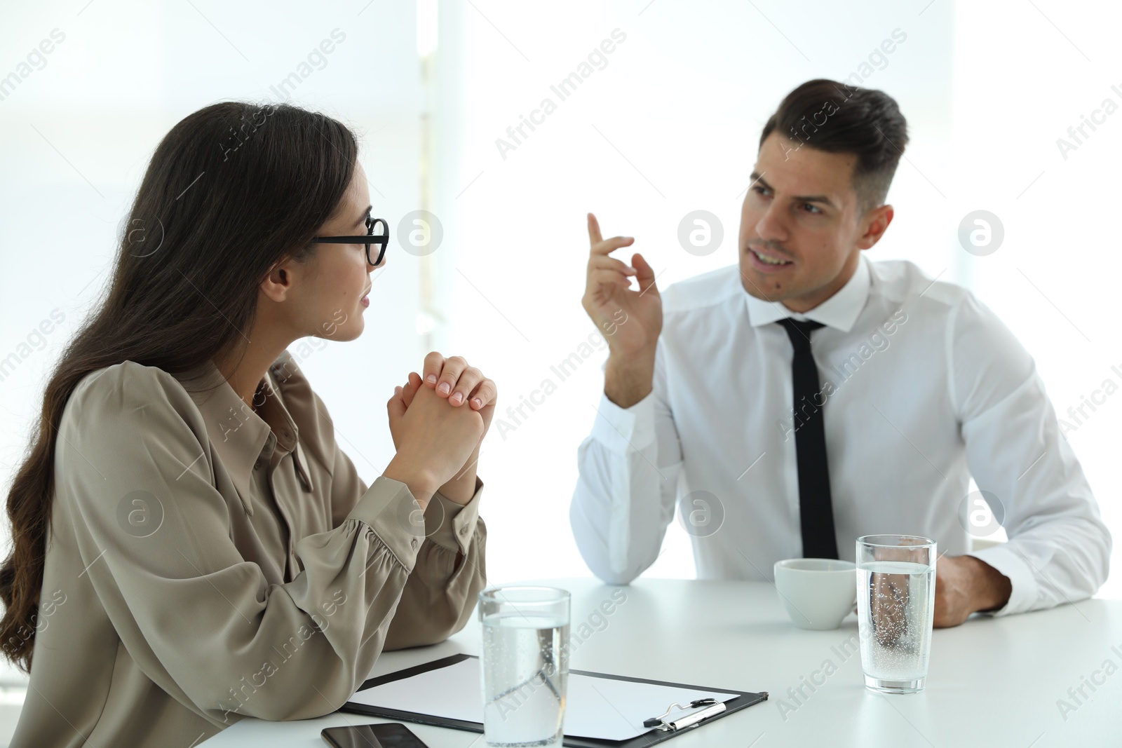 Photo of Office employees talking at table during meeting