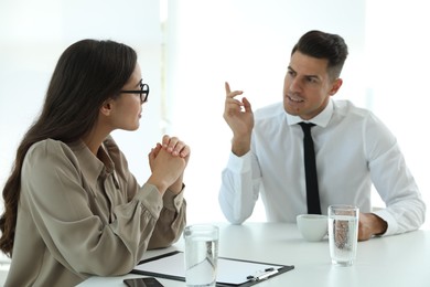 Office employees talking at table during meeting