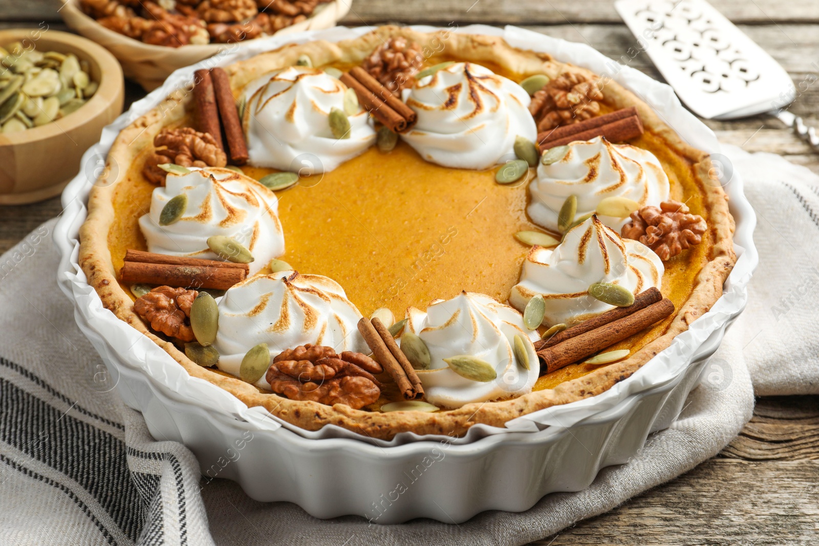 Photo of Tasty homemade pumpkin pie in baking dish on wooden table, closeup