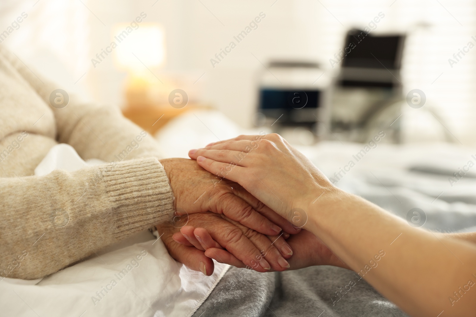 Photo of Caregiver supporting senior woman indoors, closeup. Home health care service