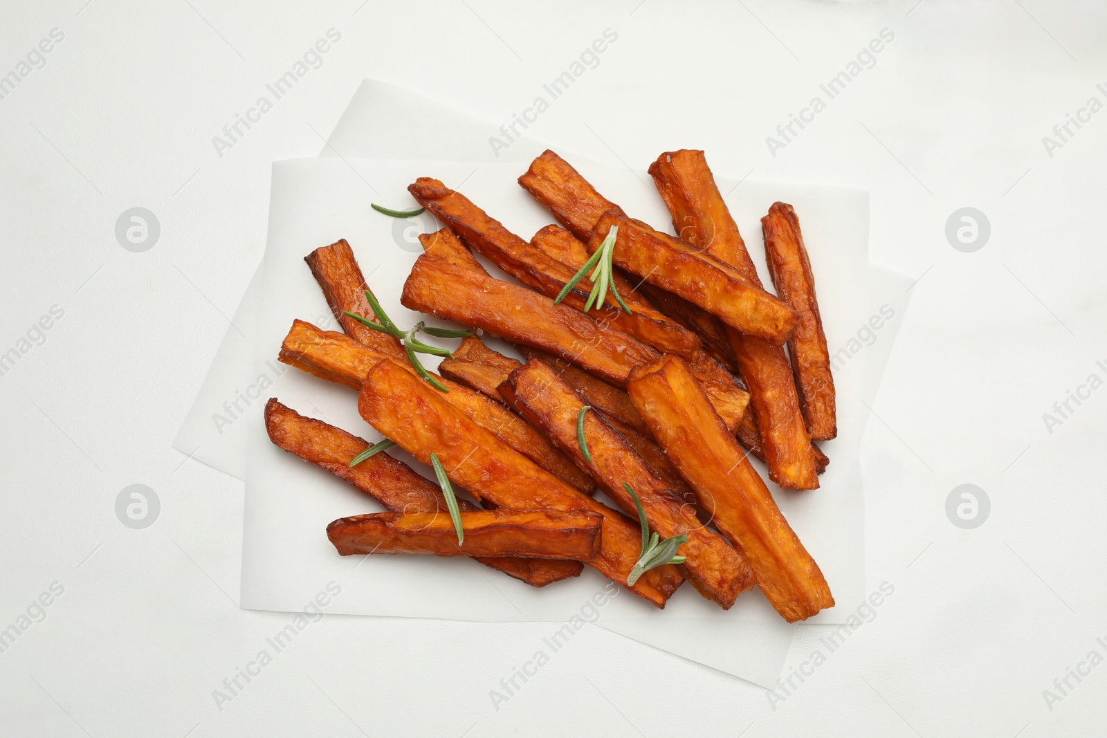 Photo of Delicious sweet potato fries with rosemary on white marble table, top view