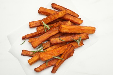 Photo of Delicious sweet potato fries with rosemary on white table, top view