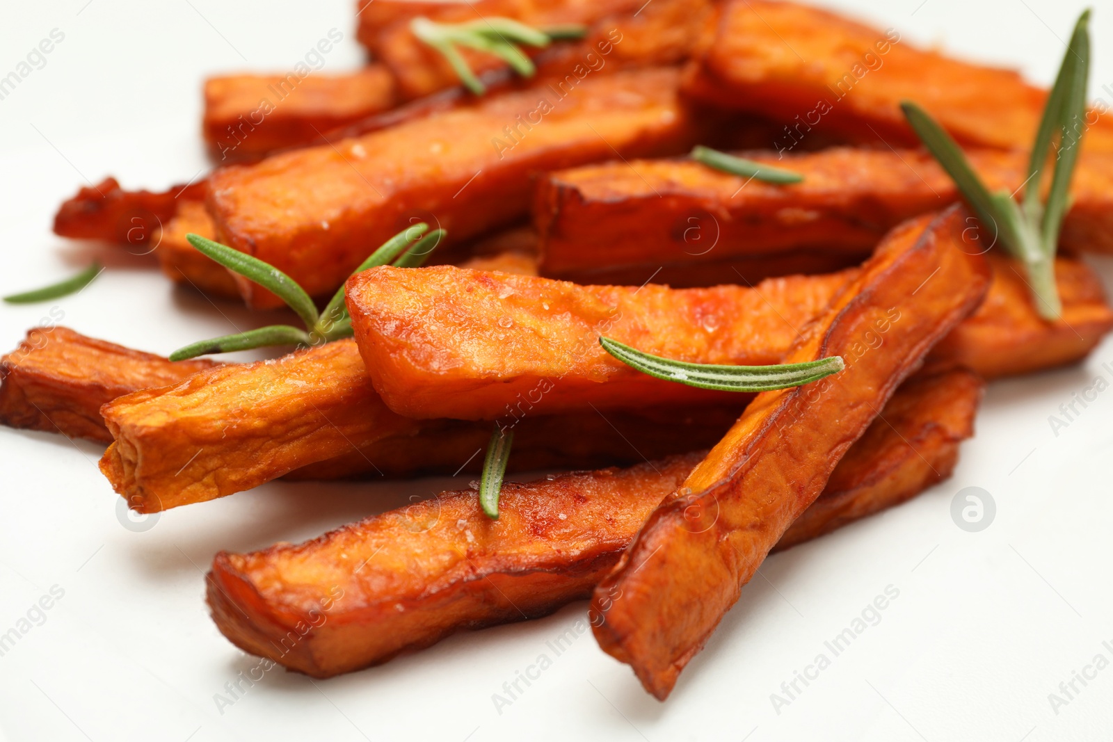 Photo of Delicious sweet potato fries with rosemary on table, closeup