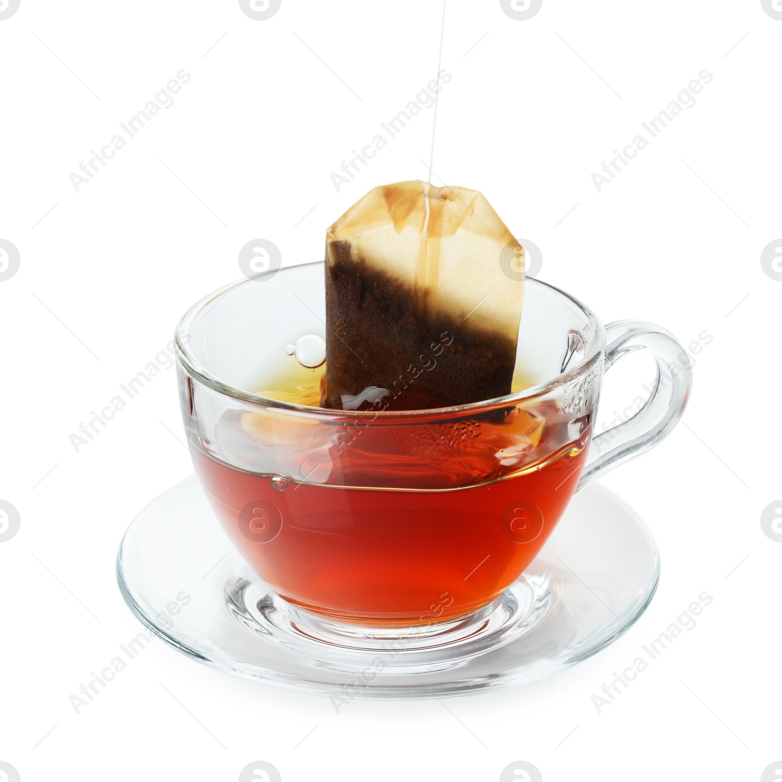 Photo of Putting tea bag into glass cup on white background