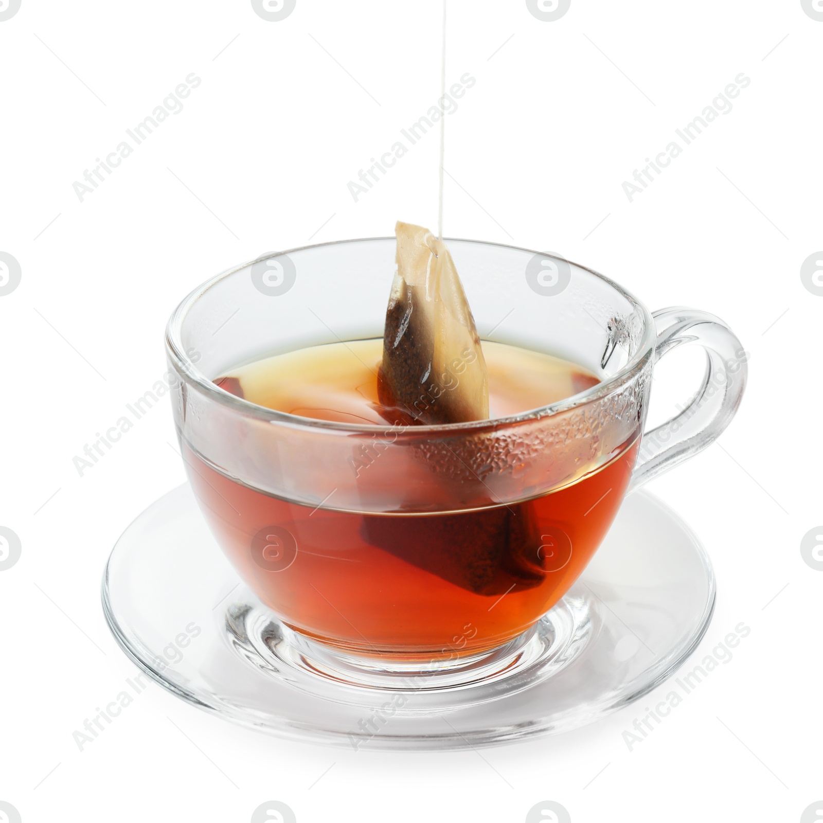 Photo of Putting tea bag into glass cup on white background