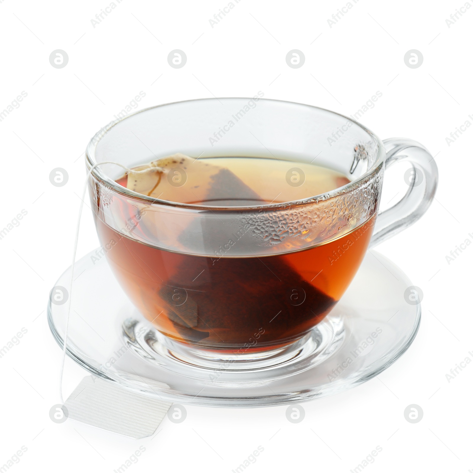 Photo of Tea bag in glass cup with hot drink isolated on white