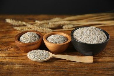 Photo of Fresh rye bran in bowls and spoon on wooden table, closeup