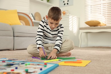 Photo of Creating vision board. Little boy drawing on card indoors