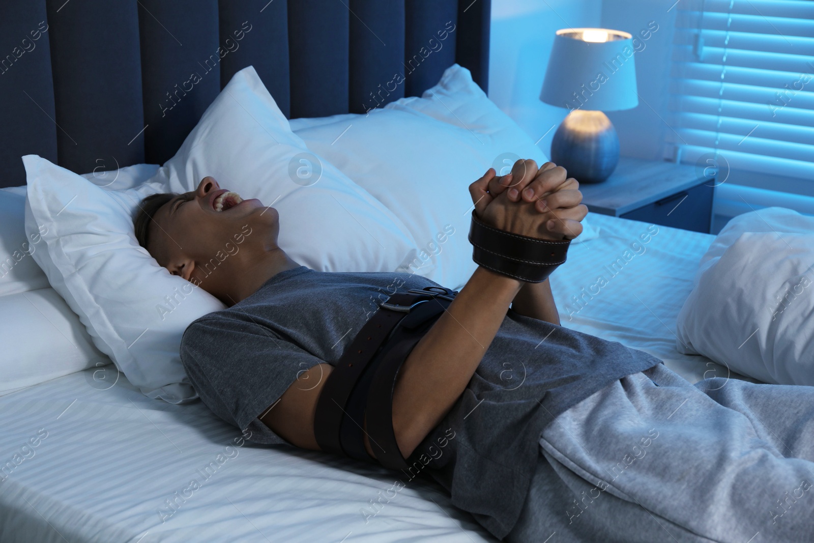 Photo of Man in sleepwalking condition screaming on bed