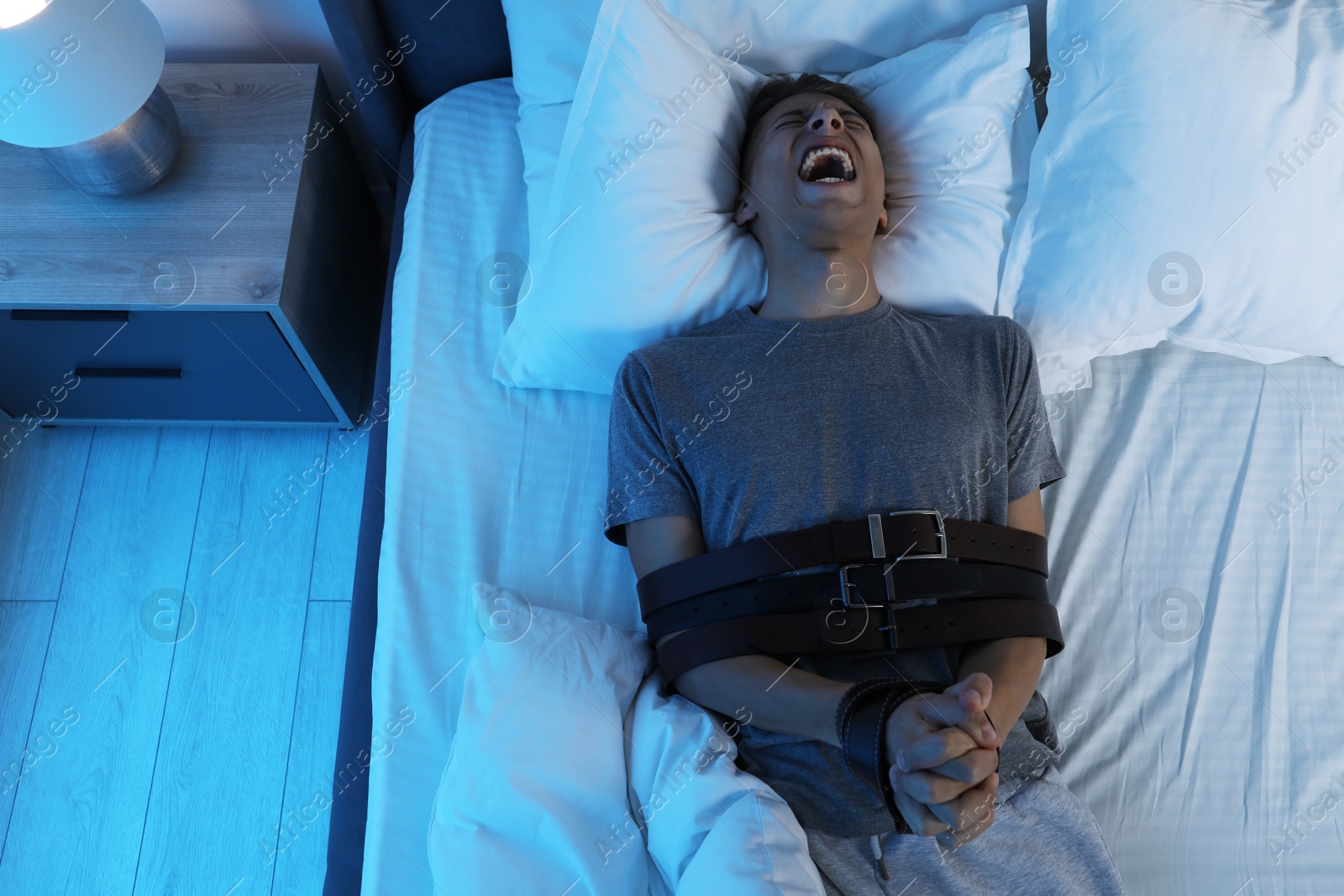 Photo of Man in sleepwalking condition screaming on bed, above view