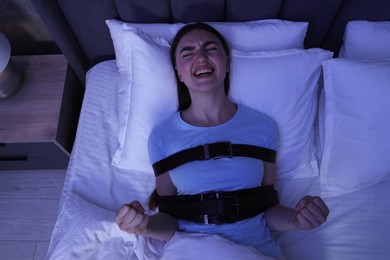 Photo of Woman in sleepwalking condition screaming on bed, top view