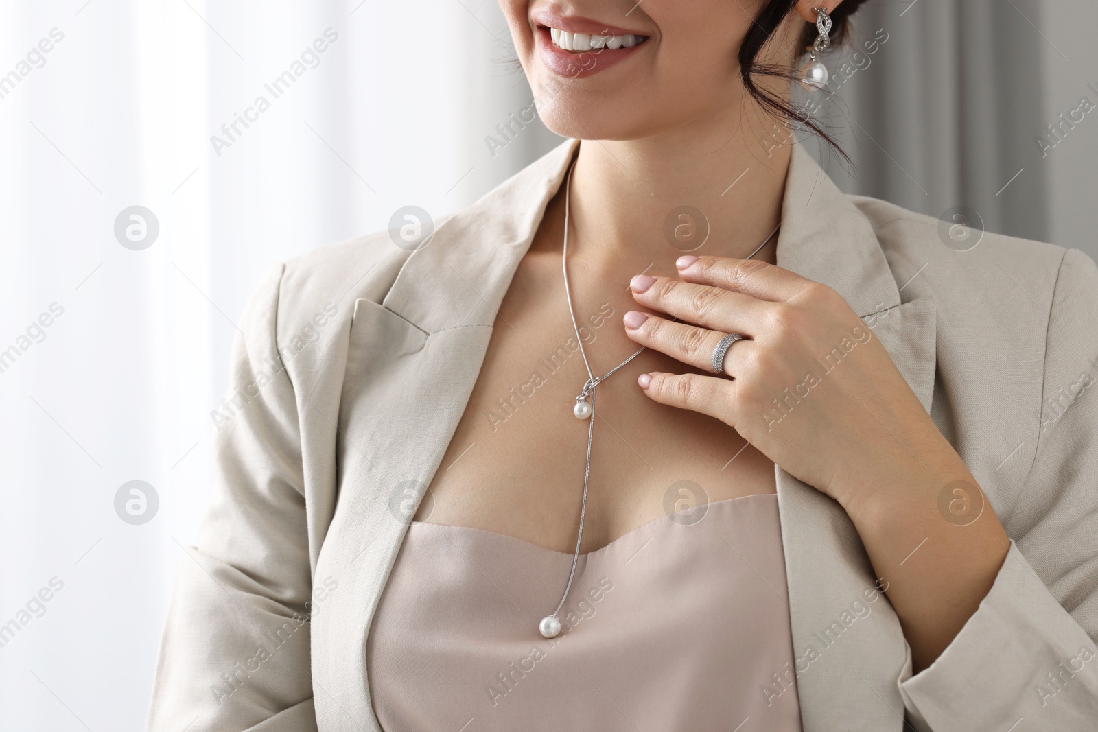 Photo of Young woman wearing elegant jewelry indoors, closeup