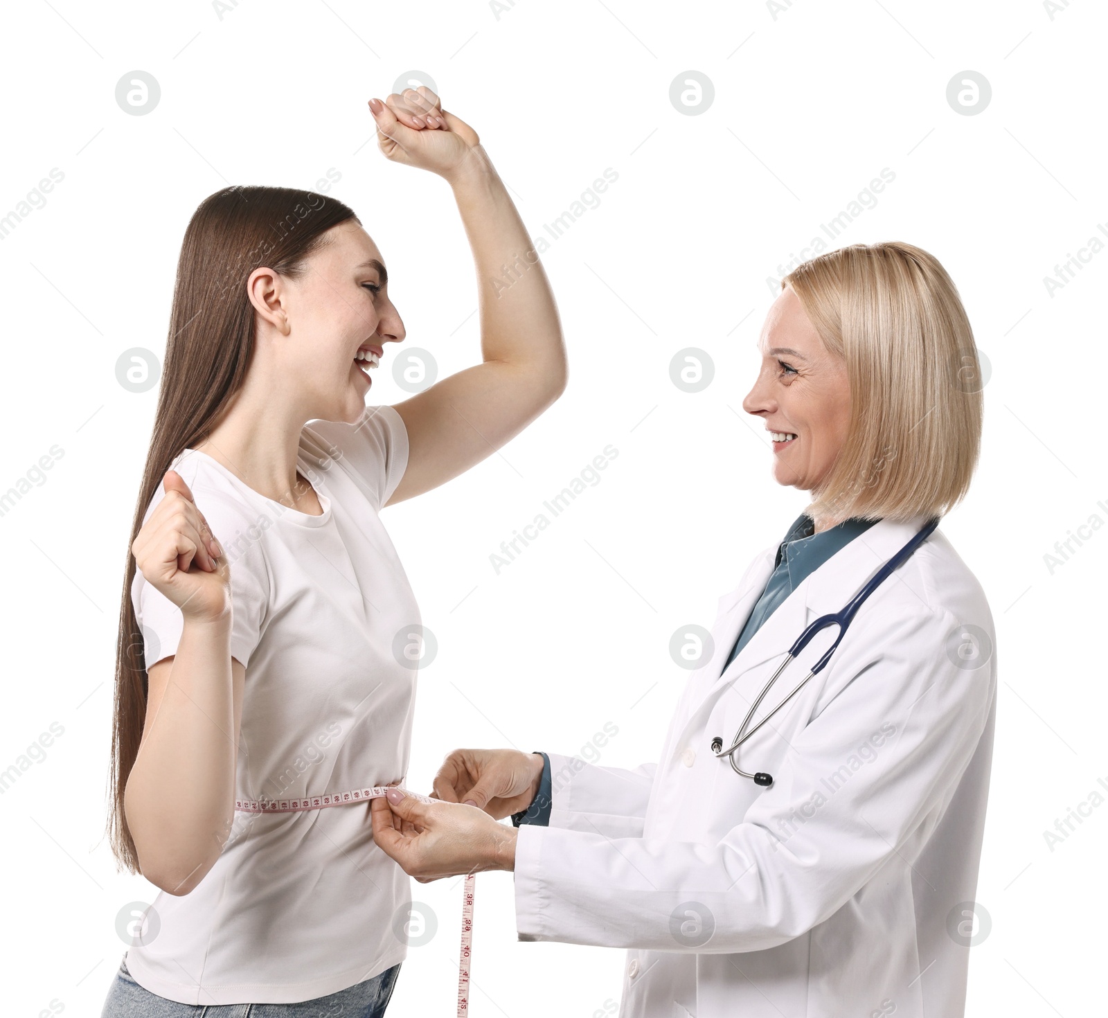 Photo of Happy woman lost weight. Nutritionist measuring patient's waist with tape on white background