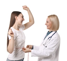 Happy woman lost weight. Nutritionist measuring patient's waist with tape on white background