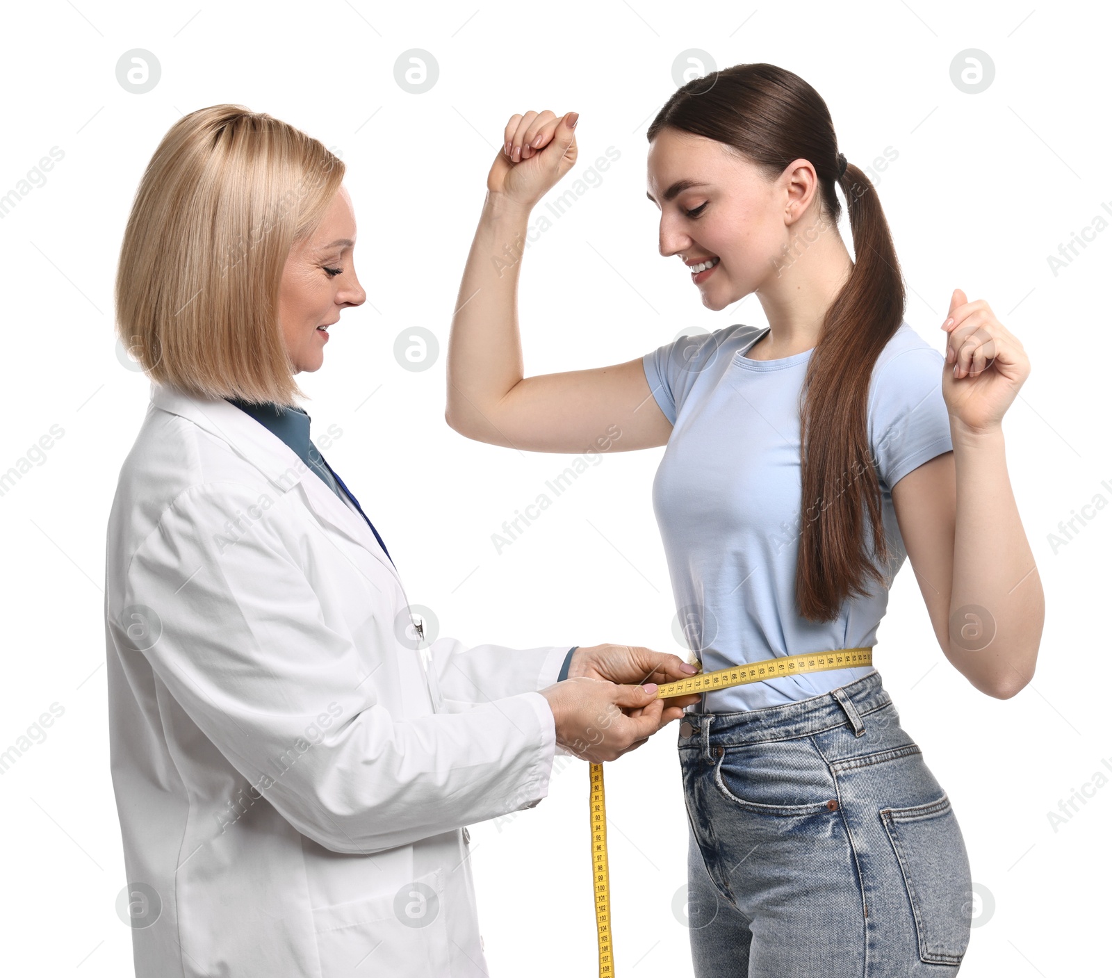 Photo of Happy woman lost weight. Nutritionist measuring patient's waist with tape on white background