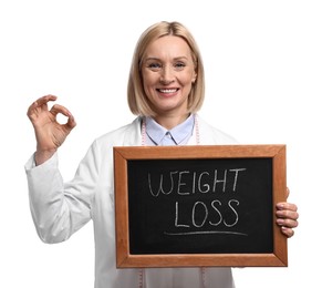 Photo of Happy nutritionist holding small blackboard with words Weight loss and showing ok gesture on white background