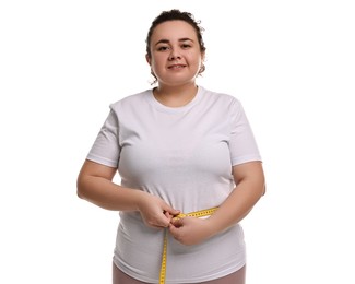 Photo of Weight loss. Happy plus size woman measuring waist with tape on white background